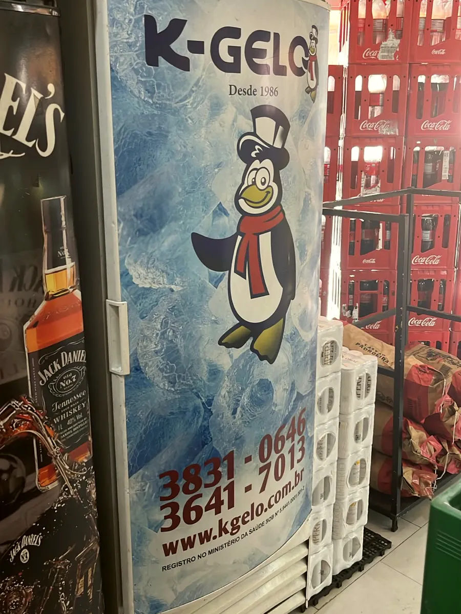 Freezer de gelo K-Gelo ao lado de engradados de Coca-Cola